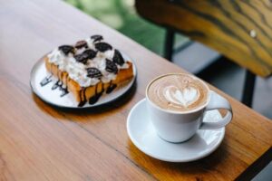 canva-coffee-latte-and-cake-on-cafe-table--MAE7ULC9uZM